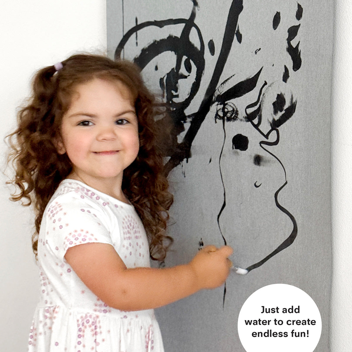 Child using water and brush to reveal illustrations on the magic water poster