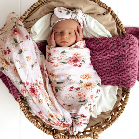 Newborn swaddled in Snuggle Hunny Birds and Blooms organic muslin wrap