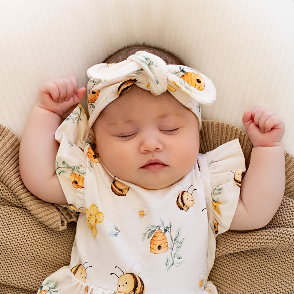Baby wearing Snuggle Hunny Bumblebees organic topknot