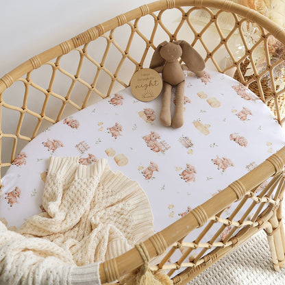 Snuggle Hunny Highland Cows organic bassinet sheet on a bassinet