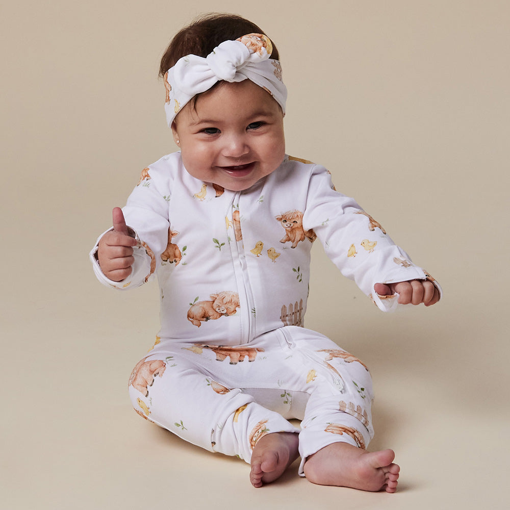 Baby wearing Snuggle Hunny Highland Cows organic snugglesuit convertible romper