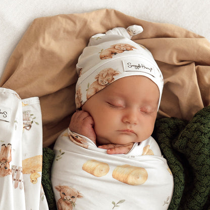Baby wearing Snuggle Hunny Highland Cows organic knotted beanie