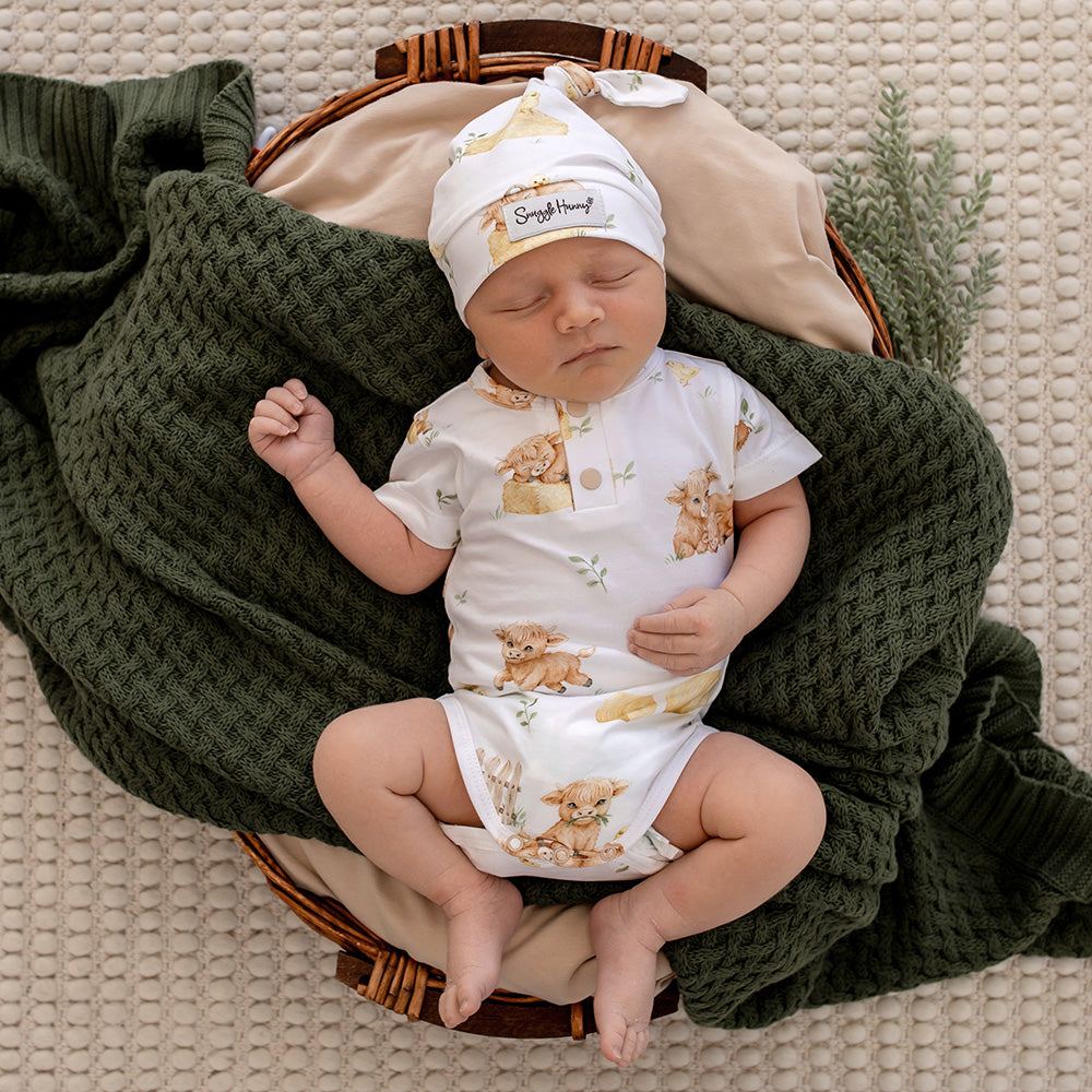 Baby wearing Snuggle Hunny Highland Cows short sleeve organic bodysuit