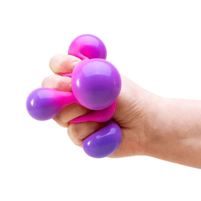 Pink NeeDoh Colour Change Cube being squeezed to reveal purple